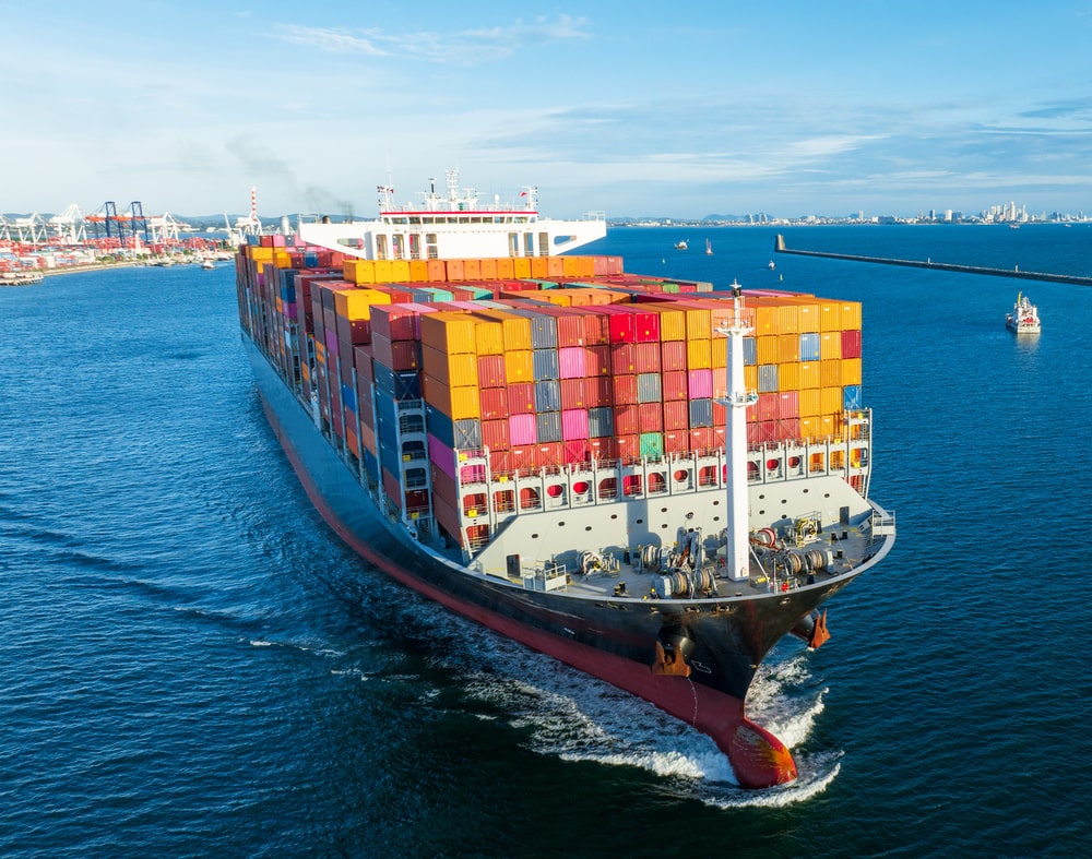 aerial-side-view-of-cargo-ship-carrying-container-2023-11-27-05-24-03-utc (1) (1)-min